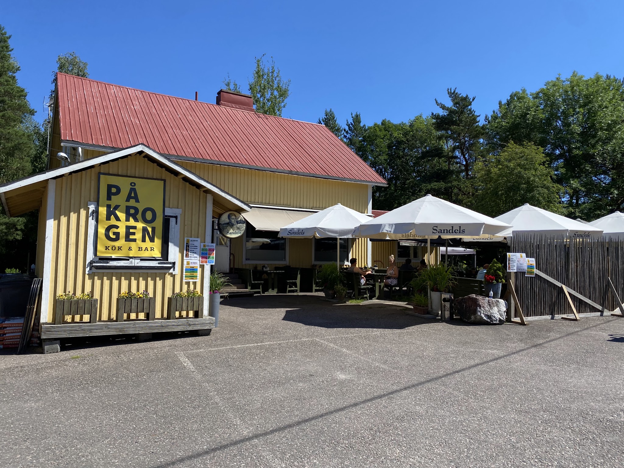 Restaurant På Krogen’s yellow building and outdoor terrace.