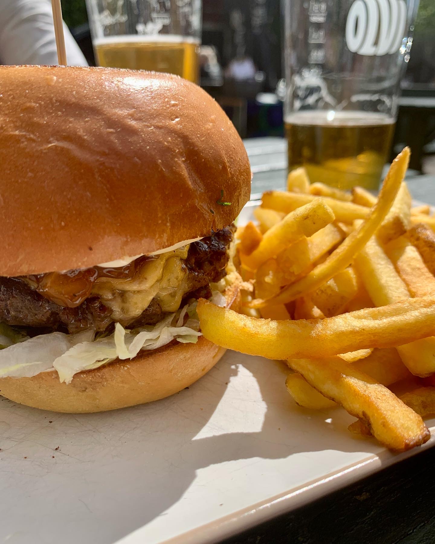 A burger with fries served on a plate.